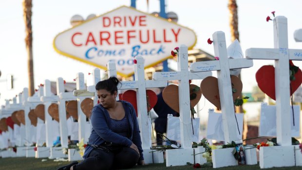 Cece Navarrette sits near a cross for her cousin, Bailey Schweitzer, who was among those killed during the mass shooting in Las Vegas. 