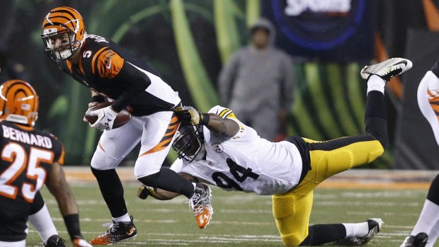 Duck and run: AJ McCarron is pulled down by Lawrence Timmons. 