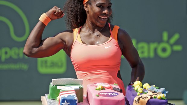 Serena Williams poses with cake celebrating her 700th career win after she defeated Sabine Lisicki.