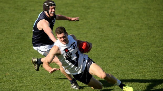 Vic Country's Kieran Collins evades Vic Metro's Sam McLarty during the U-18 match in Geelong on Sunday.