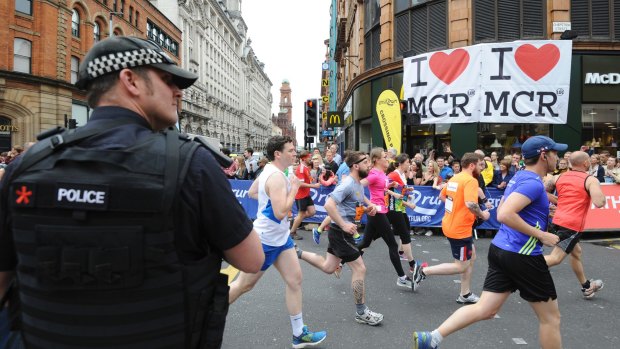 An armed police officer stands at the start of the Great Manchester Run on Sunday. 