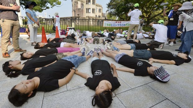 Children perform a die-in in front of the Atomic Bomb Dome at Peace Memorial Park in Hiroshima last week on the 70th anniversary of the world's first atomic bombing. 