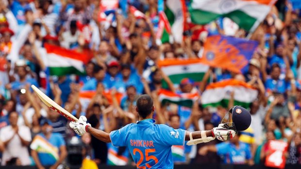 India's Shikhar Dhawan acknowledges supporters in the crowd as he celebrates after reaching a century during a Cricket World Cup match at the Melbourne Cricket Ground.