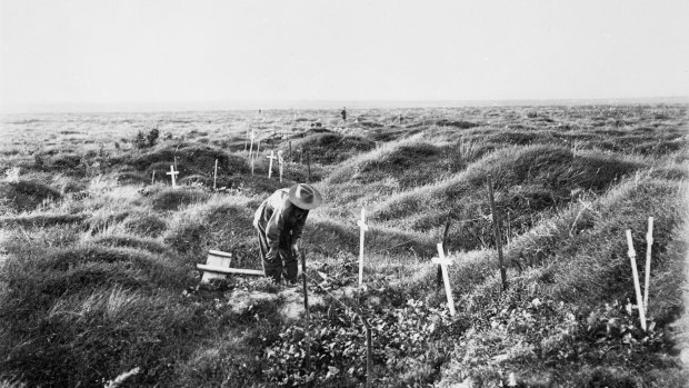 An Anzac soldier scrutinises a grave near Pozieres, along the line of OG1 trench in 1917, the year after the battle for Pozieres. An estimated 4000 Anzacs who died at Pozieres had no known graves.
