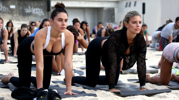 Oakley and a friend taking part in Seafolly's yoga session on Bondi Beach on Saturday morning.