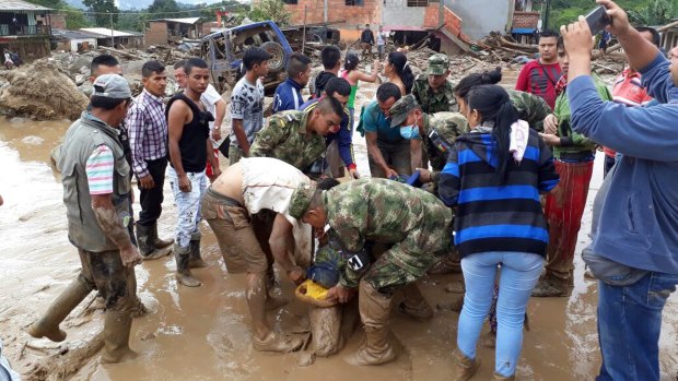 Locals work alongside soldiers to rescue the injured.