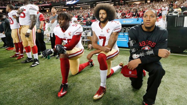 Then-San Francisco 49ers quarterback Colin Kaepernick (7) and outside linebacker Eli Harold (58) kneel during the playing of the national anthem before an NFL football game against the Atlanta Falcons in Atlanta in December, 2016.