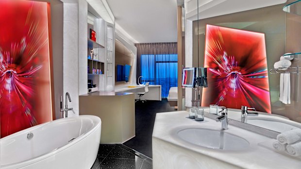 The bathroom is open-plan highlighting the  luxurious bath.