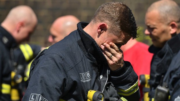 A firefighter breaks down before a minute's silence near Grenfell Tower on June 19, 2017..