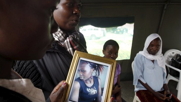 A relative carries a picture of a student killed in the university attack in Nairobi.