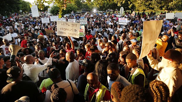 Author David Lee, lower left, speaks to a large crowd of protesters at the Craig Ranch pool where Corporal Casebolt was seen on video pinning a 14-year-old African-American girl to the ground and pointing his gun at other teenagers. 