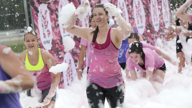 Runners have fun with foam on the obstacle course.