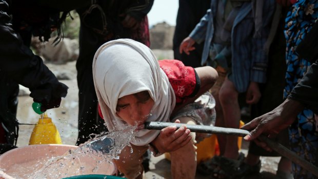 A girl drinks water from a well that is allegedly contaminated with cholera bacteria, on the outskirts of Sana'a.