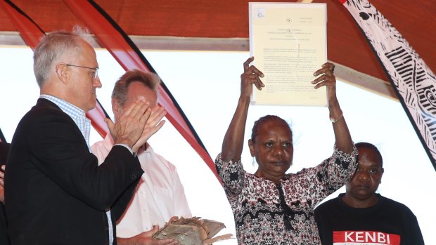 Mr Turnbull hands over the Kenbi land claim title deed to traditional owner Raylene Singh at the ceremony in Darwin.