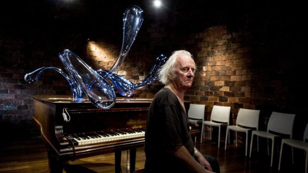 Artist Ken Unsworth with his latest work, Smokestack Piano, which involves forms made of blown glass.