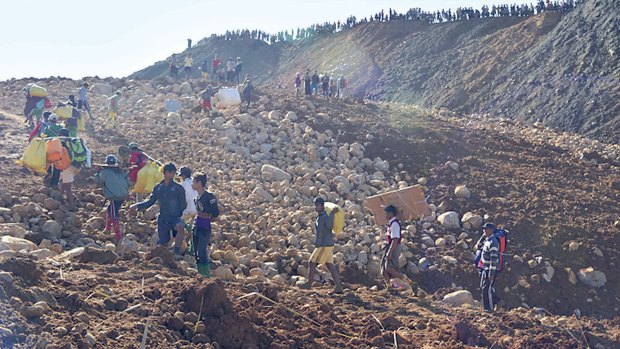 Mine workers carry their belongings after their houses were destroyed by a landslide in Phakant jade mine, Kachin State, Myanmar on Saturday. The landslide near the jade mine in northern Myanmar killed up to many people and left many missing, most of them villagers sifting through a huge mountain of tailings and waste, a community leader and businessman said Sunday.