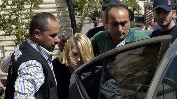 Police escort 60 Minutes presenter Tara Brown from a Lebanese courthouse before the deal was struck.