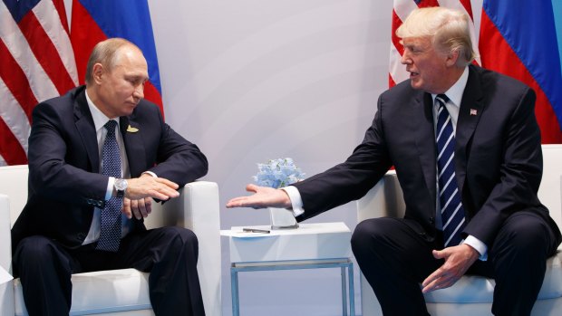 President Donald Trump reaches to shakes hands with Russian President Vladimir Putin at the G20 summit.