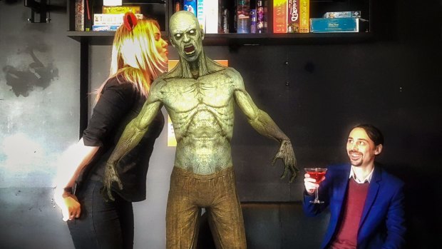 Reload Bar manager Hollie Lehmann and co-owner Jim Andrews kick back with a zombie in Australia's first augmented reality bar.
