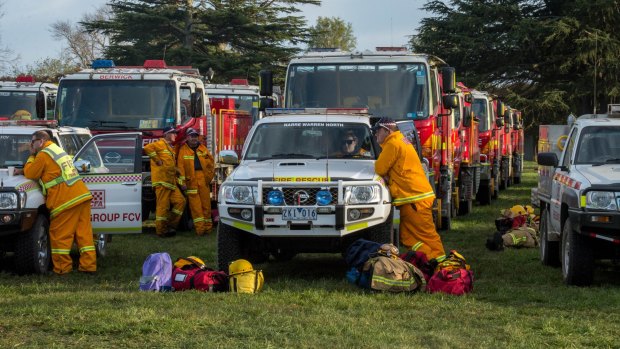 Firefighters take a brief rest before heading back to the Lancefield-Cobaw fire front.