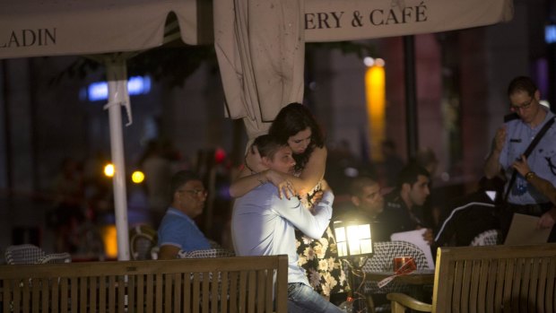 People console each other near the scene of a shooting attack in Tel Aviv, Israel, on Wednesday.