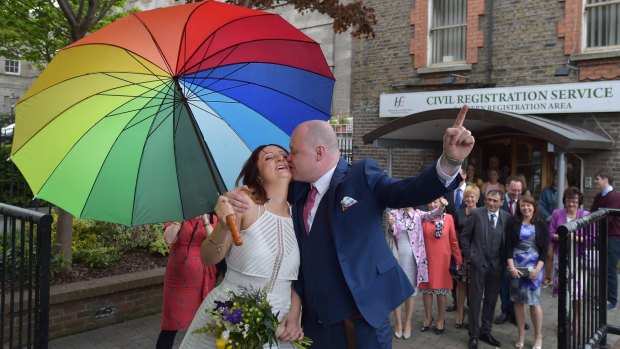 Newly married Anne and Vincent Fox celebrate their wedding and show support for same-sex marriage before casting their votes at a polling station on Friday.