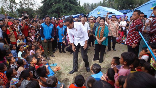 Indonesian President Joko Widodo talks to children who were evacuated from their homes on the slope of Mount Agung.