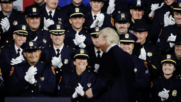 Law enforcement officers interact with US President Donald Trump after his speech  on Friday.