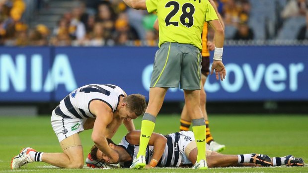 Joel Selwood takes out Jimmy Bartel's mouthguard after Bartel was knocked out against the Hawks.