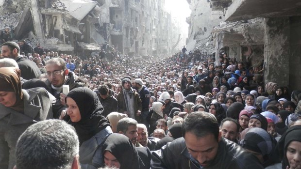 Residents of the Yarmouk camp on the outskirts of Damascus wait to receive food aid in February of last year.