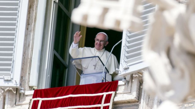 Pope Francis waves from his window overlooking St Peter's Square on Sunday. 