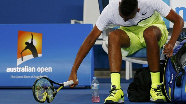 Smash it up: Nick Kyrgios breaks a racquet on Monday night.