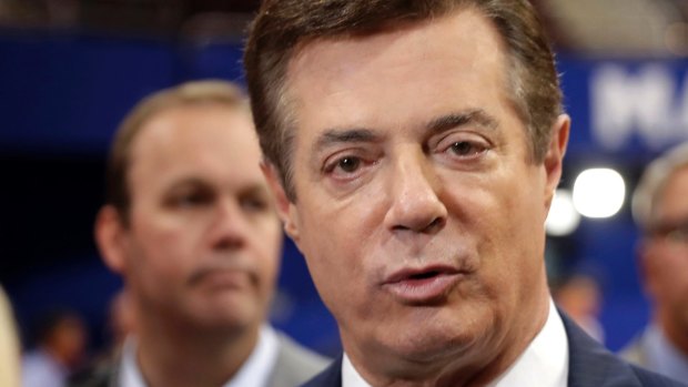 Trump's former campaign chairman Paul Manafort and deputy Rick Gates (in the background) are accused of a conspiracy against the United States relating to their lobbying work for the Ukraine.