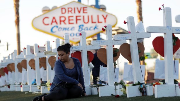 Cece Navarrette sits near a cross for her cousin, Bailey Schweitzer, who was among 58 people killed.