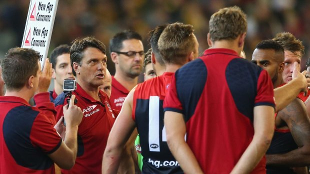 Demons coach Paul Roos talks to his players during a break in the game.