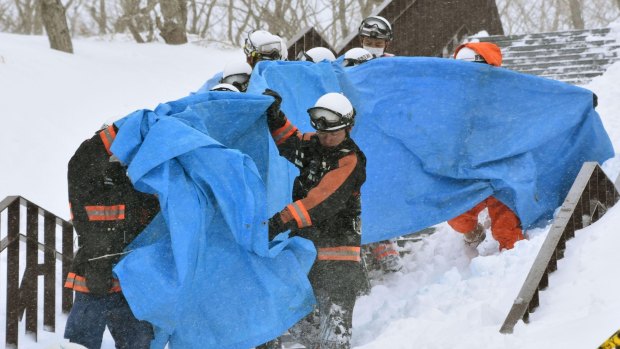 Rescuers carry the people who got injured in an avalanche at a ski resort in Nasu.
