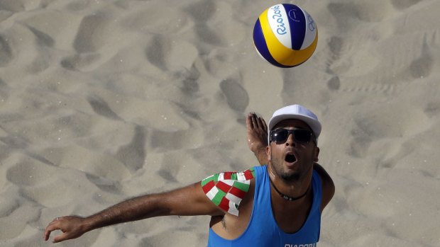 Italy's Adrian Carambula  serves during the opening men's beach volleyball game on Copacabana Beach.