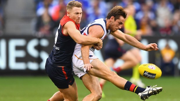 Richard Douglas, who kicked three goals, gets boot to ball as he is tackled by Demon Dean Kent.