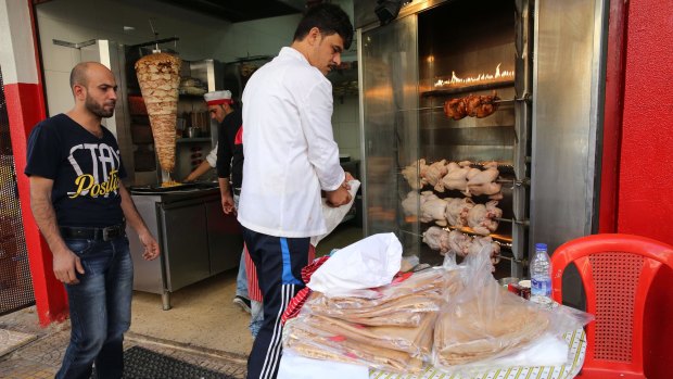 Abdul Halim al-Attar, left, with one of his employees at his restaurant in Beirut.