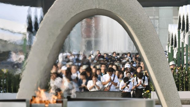 People pray for the atomic bomb victims in front of the cenotaph at the Hiroshima Peace Memorial Park on Saturday August 6.