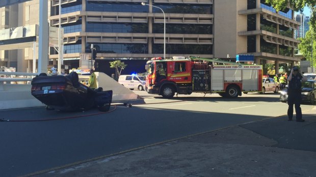 A car has flipped outside Parliament House.