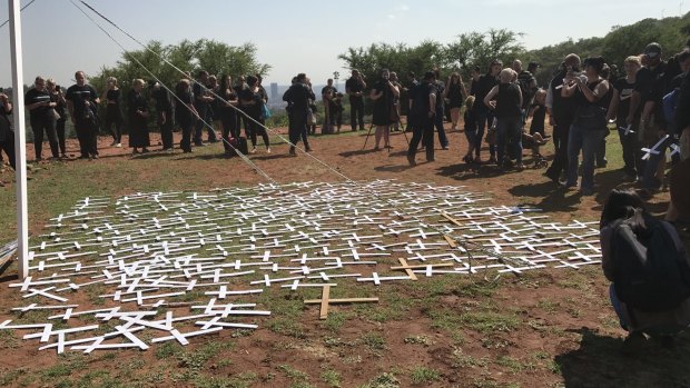 Protesters lay 'cross' symbols on the ground to protest against farmer murders in the country. 