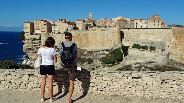 Visitors admire cliff-top views of Bonifacio in Corsica, France. 