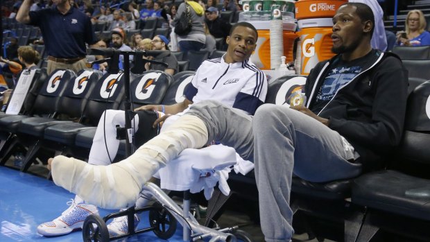 Hobbled: Kevin Durant on the sidelines with Russell Westbrook.