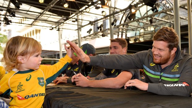 Greg Holmes high-fives a young fan during a Wallabies outing in Brisbane.