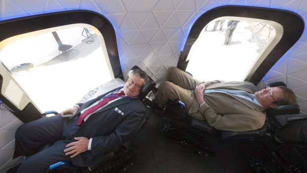 Crammed in space: Attendees of the Space Symposium test-sit the crew capsule mock up.