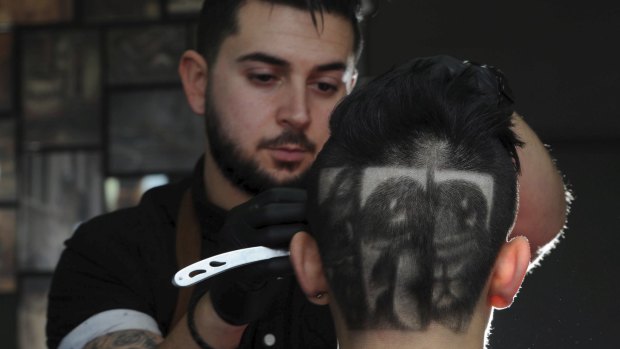 Belconnen barber Michael Daskalakis, owner of Boys 2 Men hair studio, has created Pokemon characters on the head of 18-year-old David Le, of Casey.