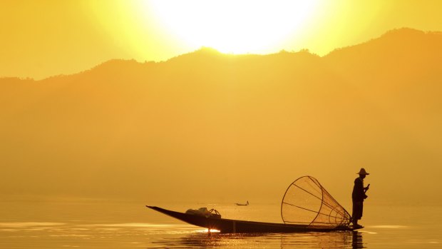 A fisherman plys his trade on Inle Lake at sunset.