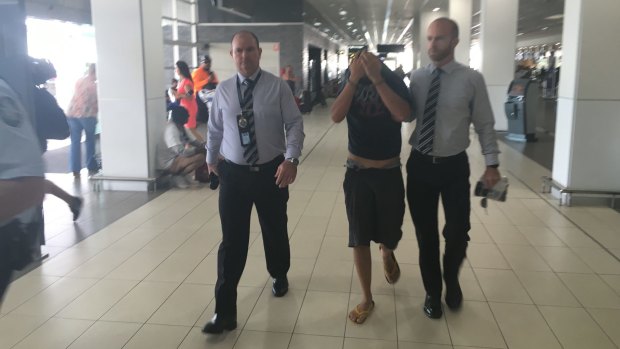 Christopher Lavery is escorted through Cairns Airport by Victoria Police homicide squad detectives in April last year.