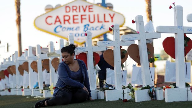 Cece Navarrette sits near a cross for her cousin, Bailey Schweitzer, who was among those killed during the mass shooting.